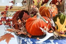 a chinoiserie bowl with fall leaves, berries, antlers, bright velvet pumpkins is a fantastic fall centerpiece