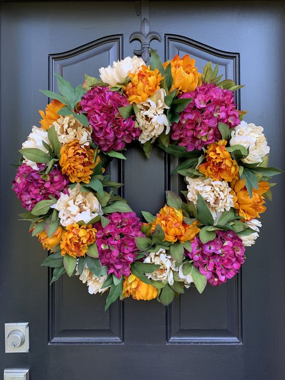a colorful fall wreath of faux greenery and colorful blooms is a nice outdoor decoration to try