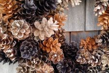 a cool wreath of pinecones of various shades is a very cool fall to winter decoration for your front door