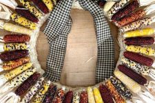 a fall wreath made of Indian corn cobs with husks and topped with a cool gingham bow is a fantastic idea for the fall