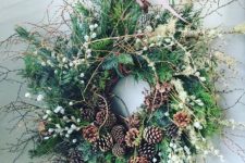 a gorgeous greenery twig fall wreath with berries, pinecones, dried grasses is very woodland-like and boho-like