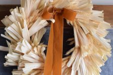 a lovely corn husk and wheat wreath with a rust-colored bow is a beautiful solution for the fall