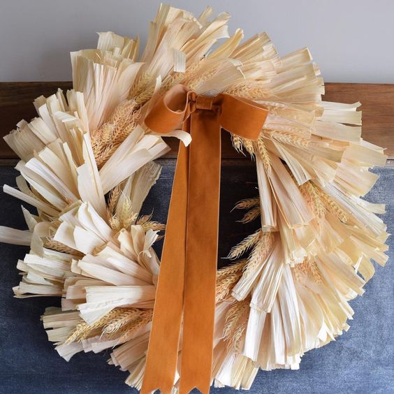a lovely corn husk and wheat wreath with a rust-colored bow is a beautiful solution for the fall