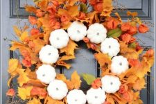 a lush fall wreath of faux leaves, dried blooms and faux pumpkins is a lovely fall decoration for your front door
