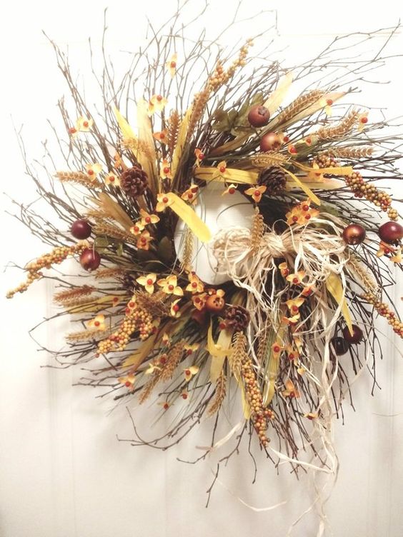 a lush twig fall wreath with faux flowers, fruits, pinecones, ribbons, feathers, wheat and hay and many other elements
