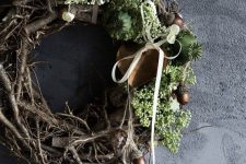 a messy fall woodland wreath with vines, greenery, seed pods, acorns, pinecones and ribbon bows is a lovely and cool idea