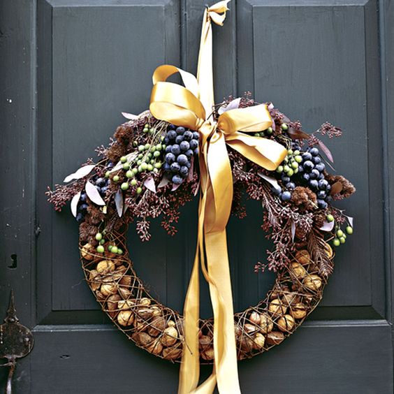 a natural wreath with nuts in the form, berries and branches on top plus a yellow ribbon bow is a cool idea