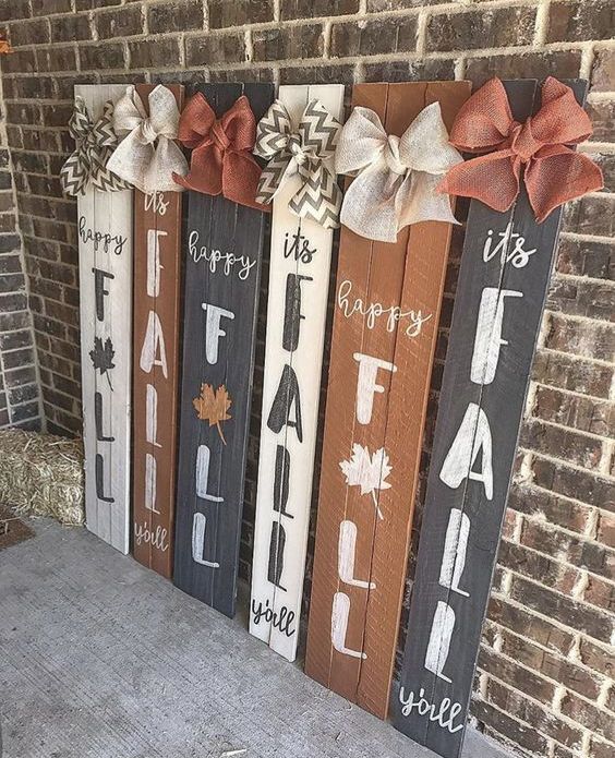 a number of fall signs in rust, black and white, all topped with contrasting burlap bows for more interest