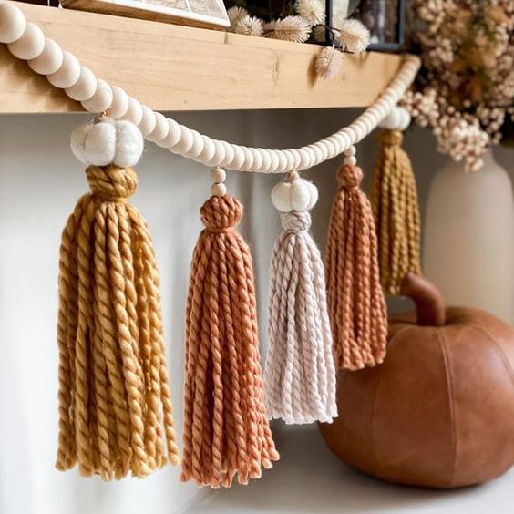 a pretty fall and Thanksgiving garland of wooden beads, felt pumpkins and bright fall-colored tassels is a great idea in fall colors