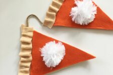 a pumpkin pie fall or Thanksgiving garland is easy to make of fabric and pompoms and looks nice and cute