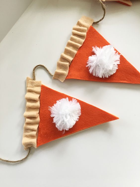 a pumpkin pie fall or Thanksgiving garland is easy to make of fabric and pompoms and looks nice and cute