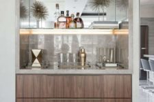 a refined built-in home bar with neutral marble, lit up shelves and sleek drawers is very chic and stylish