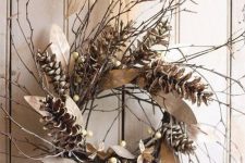 a rustic fall wreath of twigs, berries and pinecones plus dried leaves and a burlap bow is lovely and easy