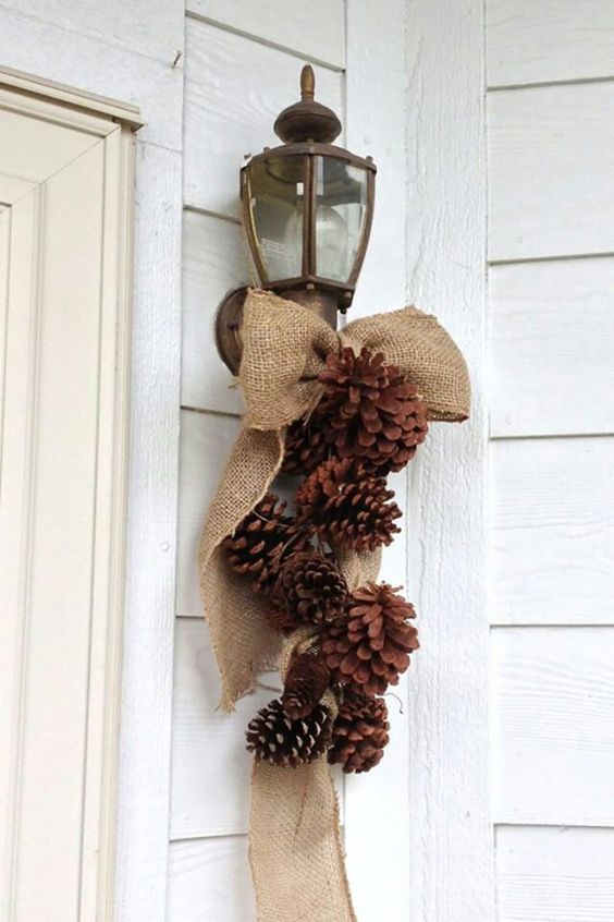 a rustic posie of pinecones and a burlap bow is a cool decoration for your front door or any other space