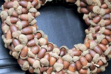 a simple and cool acorn wreath with a burlap ribbon is a lovely idea for a rustic outdoor space
