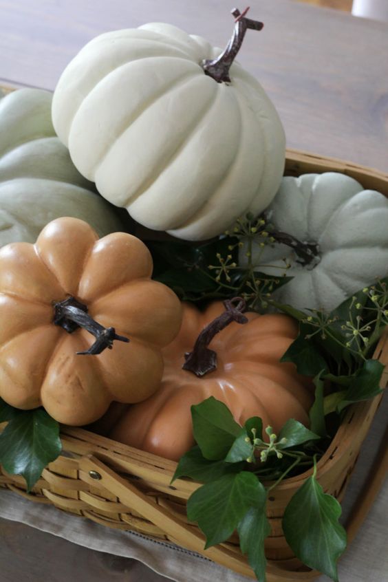 a simple basket with muted color faux pumpkins and greenery is a simple last minute centerpiece for the fall