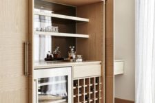 a small modern built-in bar with open shelves, a fridge and a wine bottle stand is a stylish idea that can be hidden