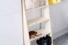 a small wooden ladder used as a shelf for shoes and bags is a simple idea for a bedroom or entryway