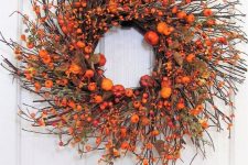 a statement fall twig wreath with orange faux pumpkins, berries, leaves and some greenery will accent your porch