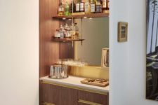 a stylish built-in bar with open shelves, a mirror, sleek drawers and lights is a cool and chic idea
