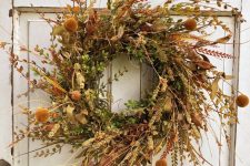 a super textural fall wreath with twigs, fall foliage, billy balls, grasses and some wildflowers is a cool fall decoration