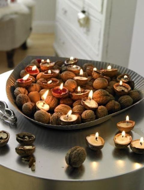 a tan bowl with nuts and candles in nut shells is a lovely centerpiece or arrangement for the fall or winter