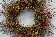 a textural twig fall wreath with foliage, berries and blooming branches is a cool fall decoration