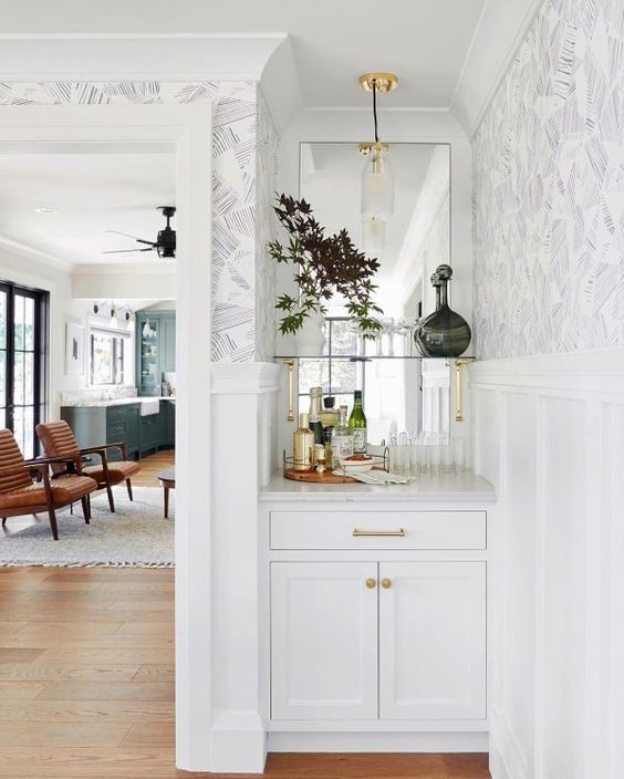a tiny built-in bar with a mirror backsplash, a glass shelf and clsoed storage compartments and a potted plant