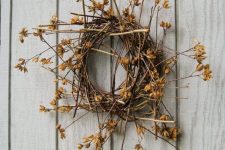 a twig and stick fall wreath with dried blooms and leaves is a simple and cool fall decoration with a decadent feel