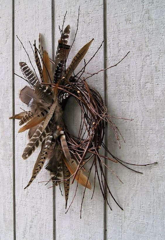 a vine and twig fall wreath with lots of various feathers is a gorgeous fall decoration to rock