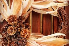 a vine wreath with oversized corn husks and pinecones on one side is a fantastic idea for a rustic space