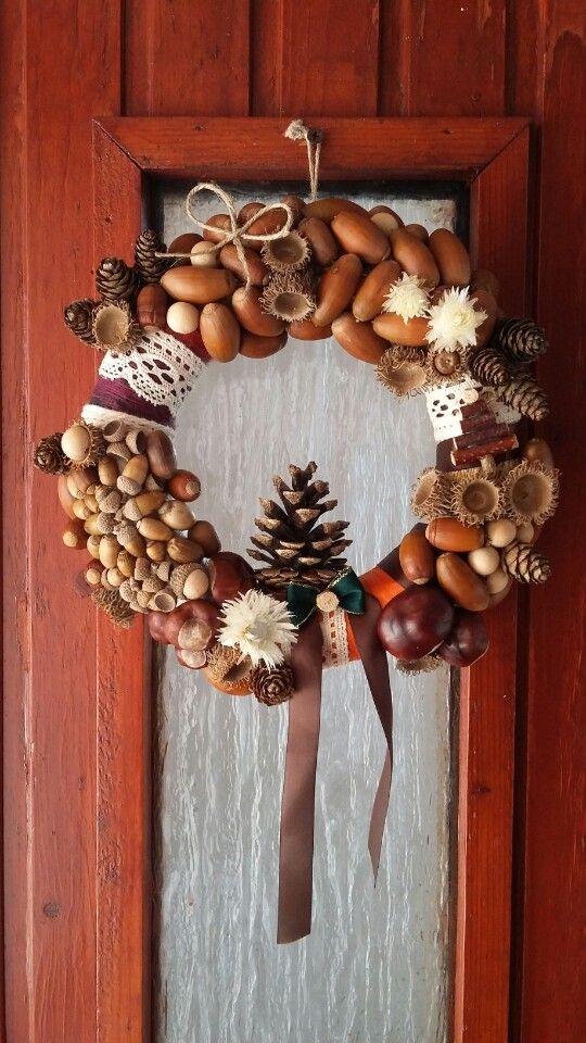 an eye-catchy fall to winter wreath of acorns, nuts, pinecones, dried blooms, lace, ribbon and a twine bow is a cool idea