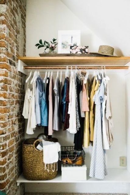 an open closet  in the corner with a holder for hangers and an open shelf plus baskets is a cool way to use a small nook