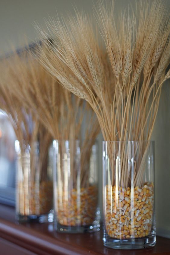 clear glass vases with wheat and candy corn are nice decor for mantel and can be used as centerpieces