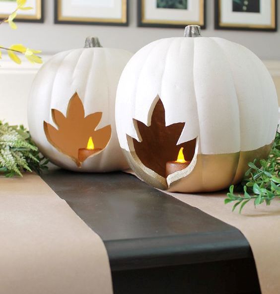 color block white and gold pumpkins with leaf cutouts and candles inside are amazing as fall lanterns