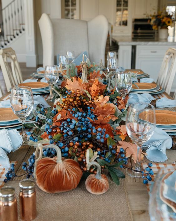 rust velvet pumpkins, berries, greenery and dried fall leaves for a large and bold fall centerpiece