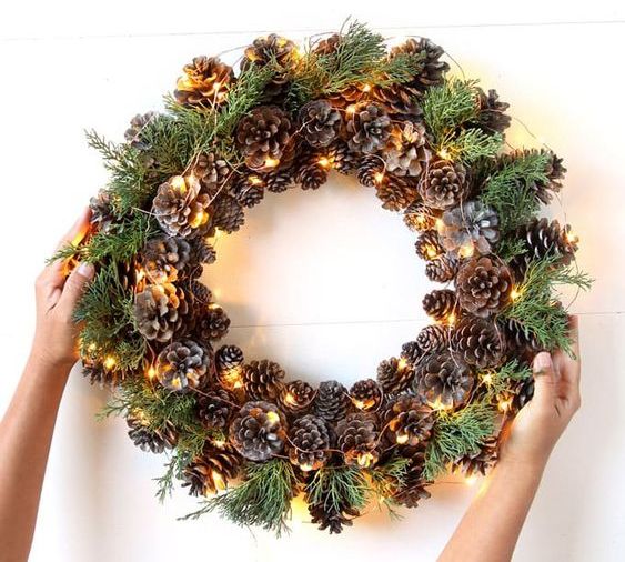 such a pinecone, evergreens and lights wreath can be a nice decoration from fall to winter and is easy to make