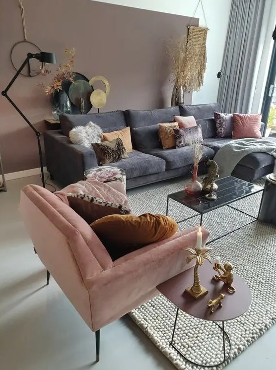 a beautiful living room with a mauve accent wall, grey and pink furniture, touches of black and gold is cool
