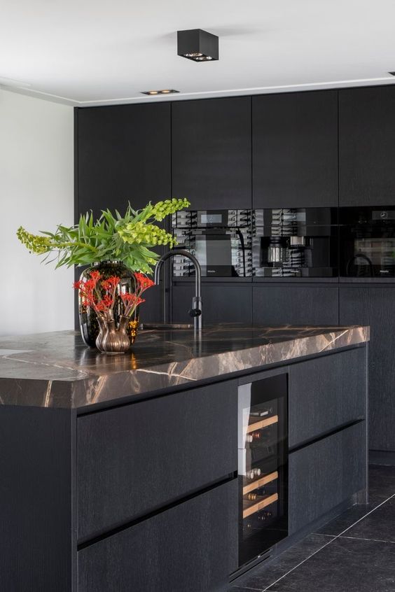 a black minimalist kitchen with sleek cabinets, a large kitchen island with brown stone countertops is pure elegance