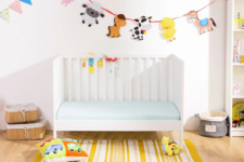 a colorful nursery with a Sundvik crib, bright animal garlands, toys, a storage unit and baskets