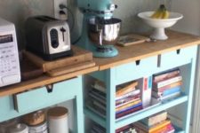 a cooking kitchen area made of two IKEA Forhoja carts in light blue, with wooden countertops is very space-saving