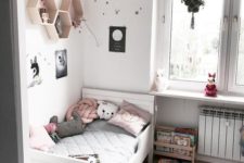 a cozy and soothing kid’s room done in white, black and pink, with a white IKEA Sundvik bed, hex shelves, paper lanterns and a potted plant
