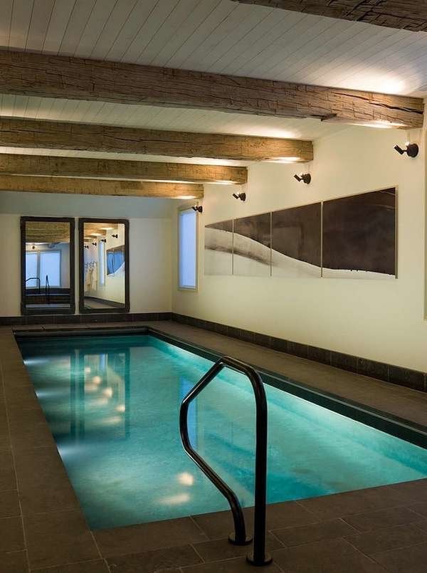 a creative space with a turquoise pool, wind worn wooden ceiling beams and a four panel wall art that reminds of a sand dune