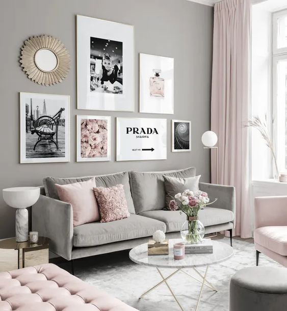 a light-filled living room with grey walls, a grey sofa, light pink chairs and a daybed, pink pillows, a gallery wall and light pink curtains