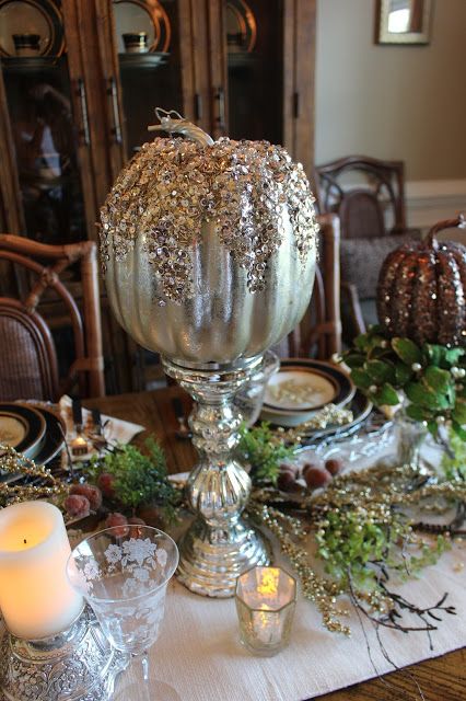 a metallic pumpkin with sequins and glitter on top on a vintage mercury glass stand as a glam centerpiece