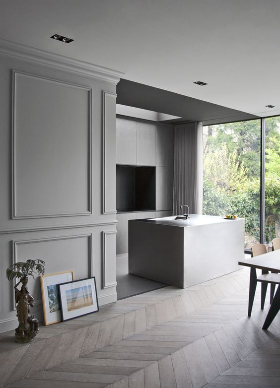 a minimalist grey space is made more refined and soft at the same time with molding on the walls and a parquet floor