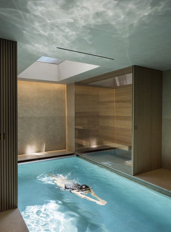 a minimalist pool space with a wooden deck, a small sauna and a skylight to fill the space with natural light is awesome