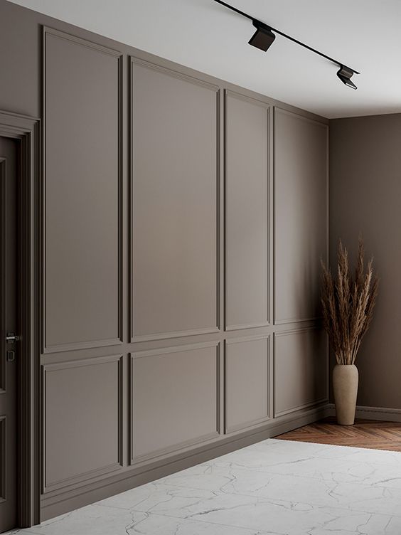 a modern classic space with a warm grey wall with molding that adds chic and instantly elevates the style of the room