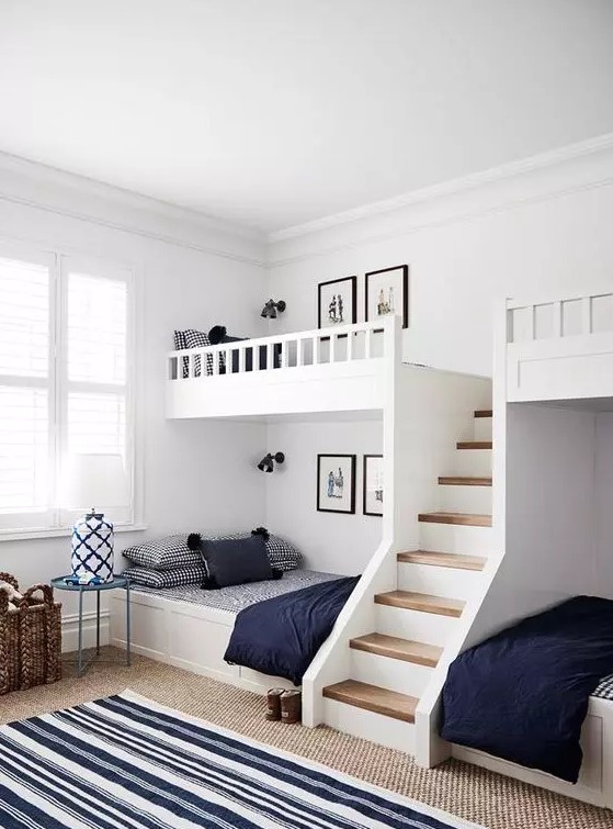 a modern farmhouse kids' room with built-in bunk beds, navy and white bedding, layered rugs and side tables and baskets