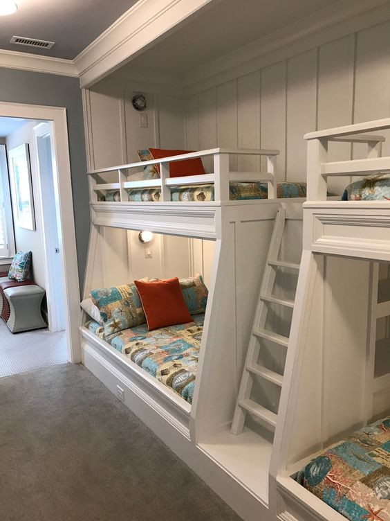 a modern kids' room with built-in bunk beds, bright printed bedding, built-in lights is a cool and welcoming space for children